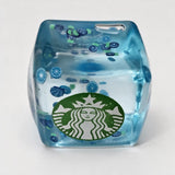 Clear blue jelly ice cube squishy with little citrus slices floating inside