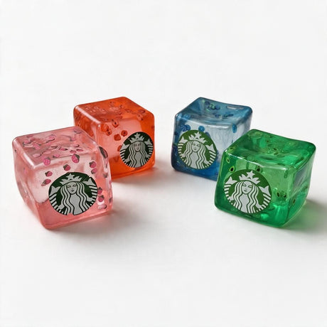 Four jelly ice cube squishies in pink, orange, blue and green with tiny fruit pieces inside