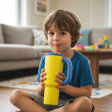 Boy holding a yellow tumbler with a royal blue lid and handle and an orange straw