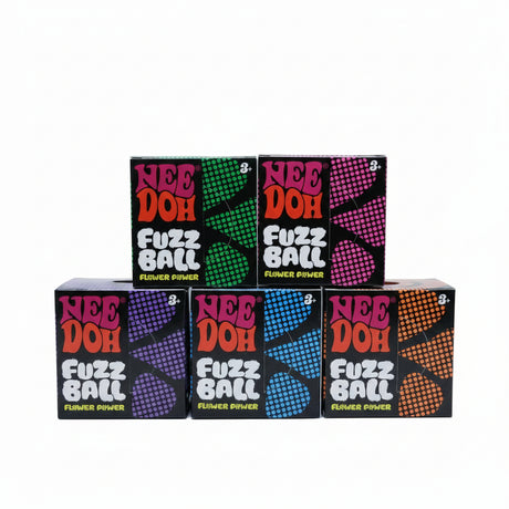 Multiple boxes of Nee Doh Fuzz Ball on a cardboard surface with plastic bags in the background.