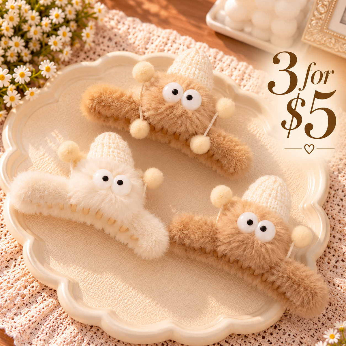Three fuzzy claw clips in tan and cream with googly eyed creatures, knit hats and pom pom antennae