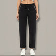 Black pants with white trim worn by a person on a gray background