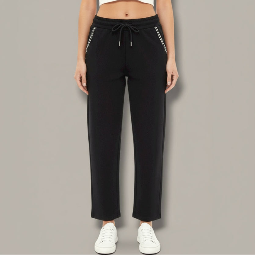Black pants with white trim worn by a person on a gray background