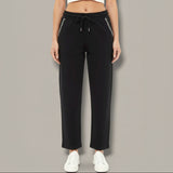 Black pants with white trim worn by a person on a gray background