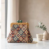 Red and navy diamond pattern handbag on white marble beside a mug