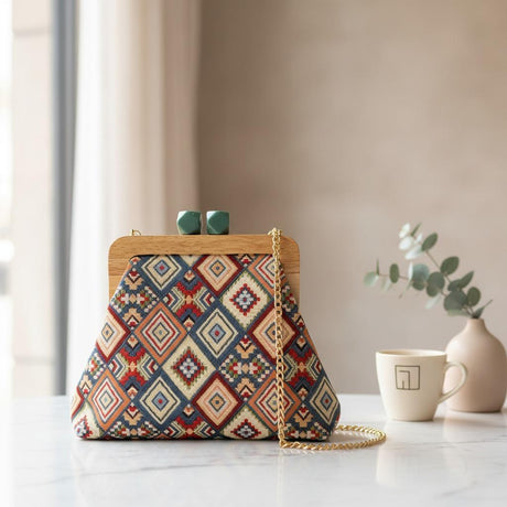 Red and navy diamond pattern handbag on white marble beside a mug