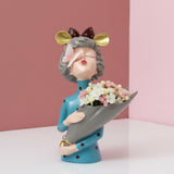 Teal polka dot dress, gold mouse ears and a butterfly on her nose above a grey cone vase