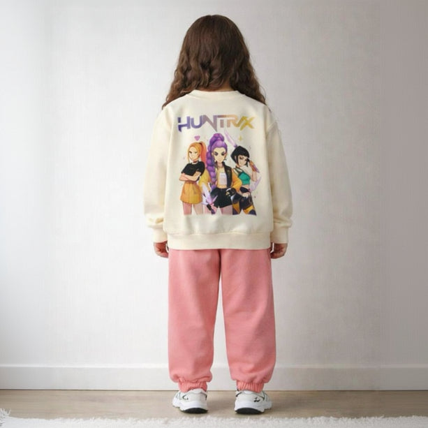 Back view of a cream girls sweatshirt with three Huntrix singers print above pink joggers