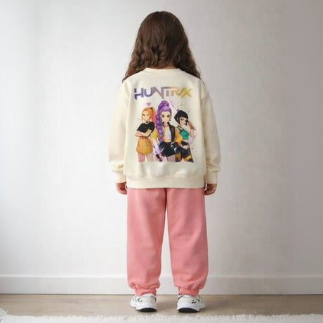 Back view of a cream girls sweatshirt with three Huntrix singers print above pink joggers
