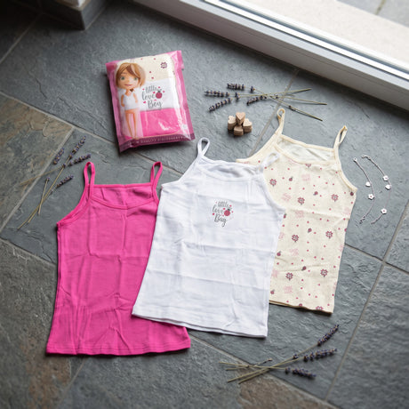 Three girls camisole vests in pink, white and a cream floral and heart print