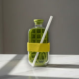 Olive green glass drink bottle with a grid chiller insert and a yellow silicone sleeve