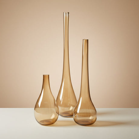 All three amber teardrop vases standing empty side by side in graduated heights