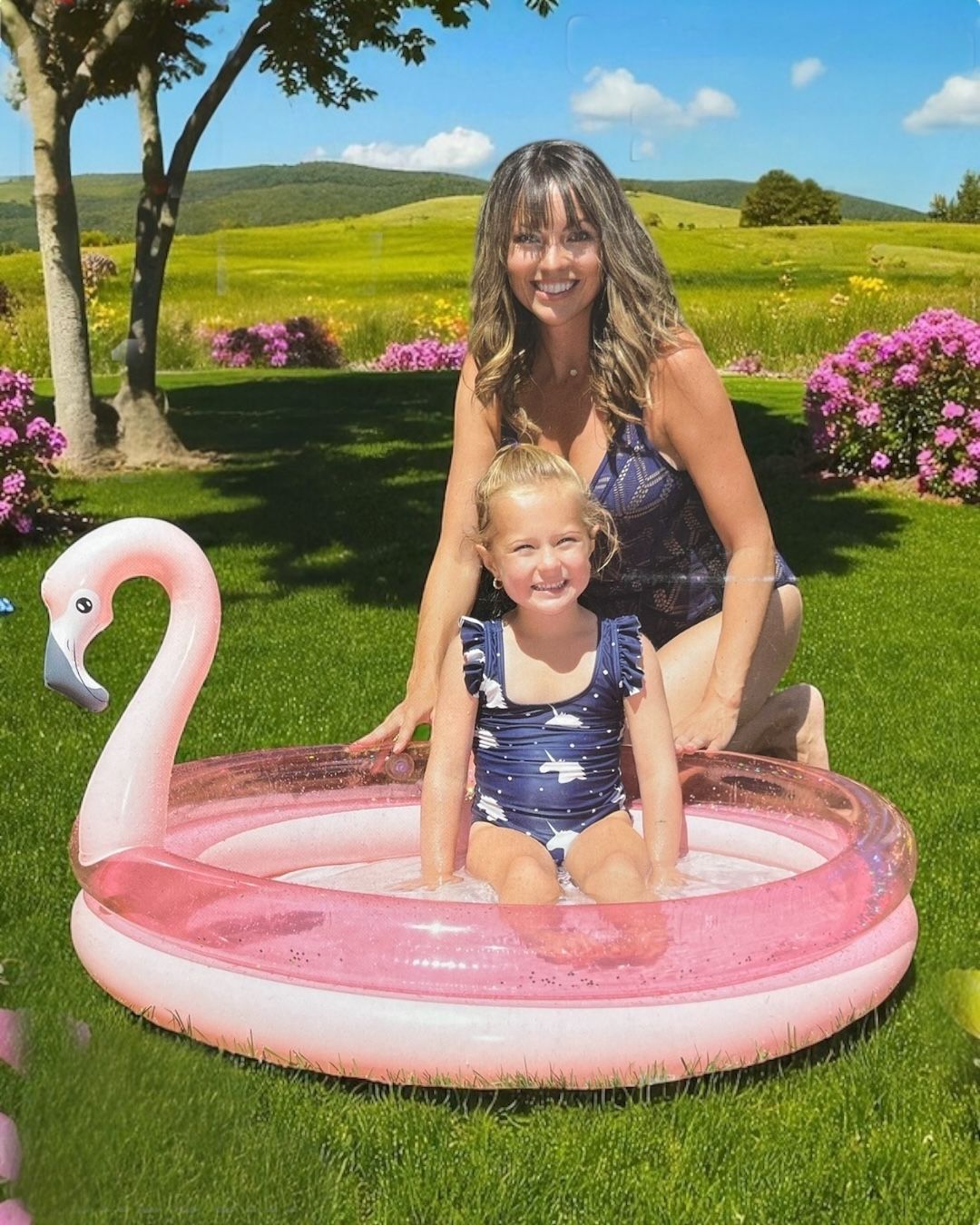 Pink two ring paddling pool with glitter confetti vinyl and a flamingo head backrest, child sitting in water