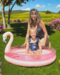 Pink two ring paddling pool with glitter confetti vinyl and a flamingo head backrest, child sitting in water