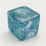 Blue glitter jelly cube squishy with swirls of sparkle inside