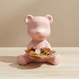 Pink bear-shaped jewelry holder with a watch on a beige background