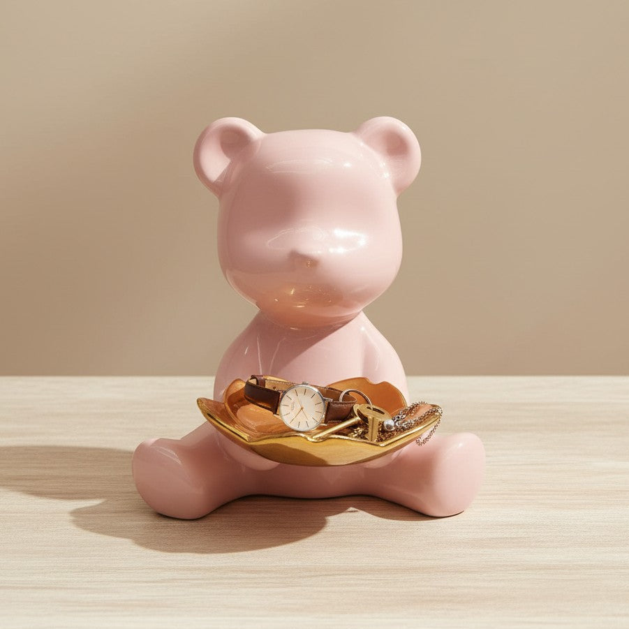 Pink bear-shaped jewelry holder with a watch on a beige background