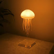 Glowing jellyfish lamp casting warm light on a bedside table