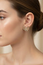 Close-up of a woman wearing a decorative bow-shaped earring with a blurred background