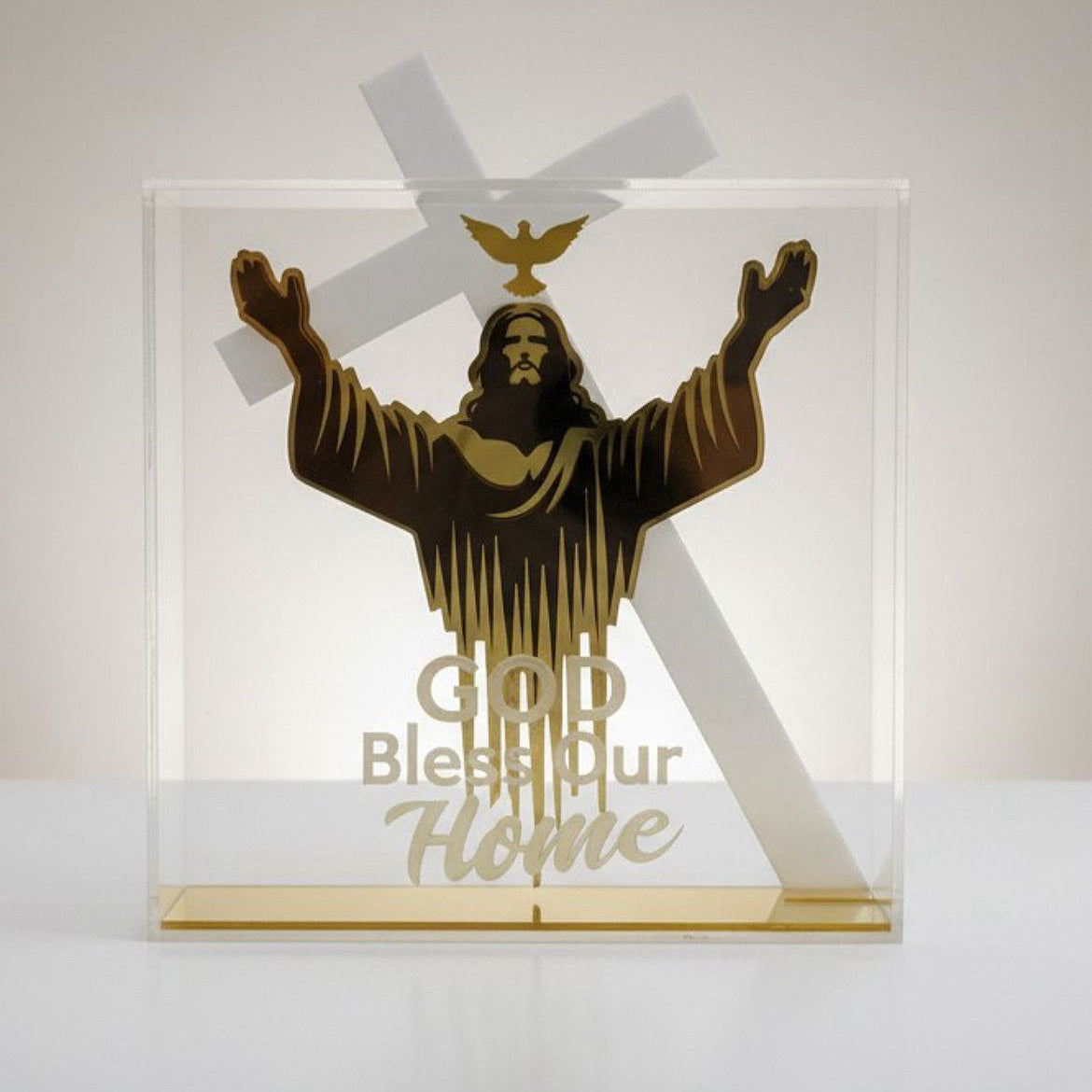 Gold figure of Christ with arms raised beneath a dove, lettered God Bless Our Home