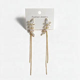Pair of marquise crystal leaf earrings with long gold chain drops on a display card