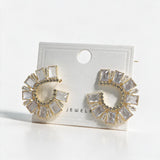 Pair of gold emerald cut crystal crescent earrings on a white display card