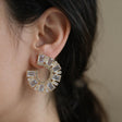 Gold crescent earring set with large emerald cut crystals worn on the ear