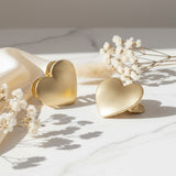 Two brushed gold heart claw clips beside dried babys breath flowers