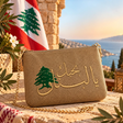 Handmade gold pouch with gold Arabic I love you Lebanon embroidery and a green cedar, with the Lebanese flag behind