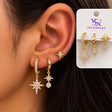 Ear wearing a large crystal north star hoop, a small star huggie and a star stud with a crystal drop