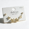 Gold stud set with round crystal studs, small open bows and larger pave edged bows on a white card