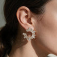 Gold spiral earring lined with tapered baguette crystals worn on the ear