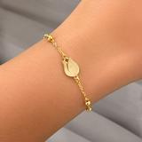 Close view of the flat gold tulip charm sitting between round beaded links