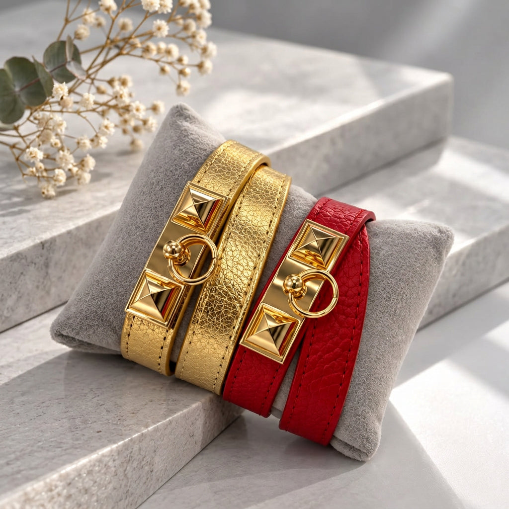 Gold and Red pyramid stud wrap bracelets with gold ring clasps displayed on a grey velvet cushion