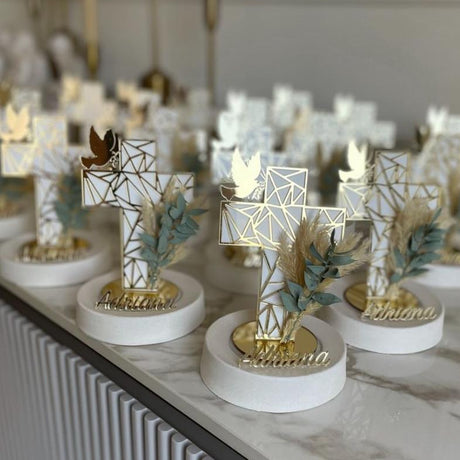White lattice cross with a gold dove on a round base, a name in gold script below