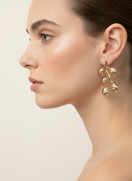 Golden grace earrings worn by a model on a neutral background