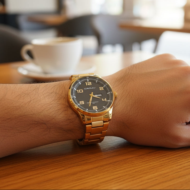 Person wearing a gold prestige watch with a black dial on a blurred background
