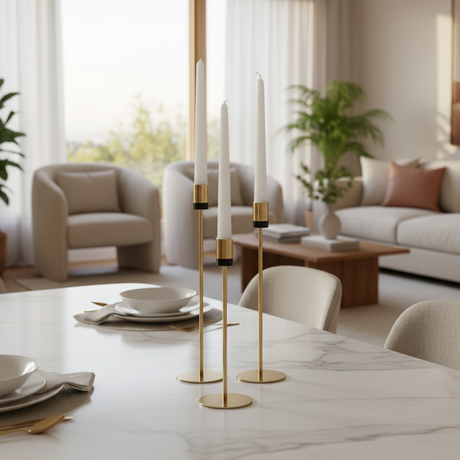 The black collared holders on a marble dining table set with bowls and gold cutlery