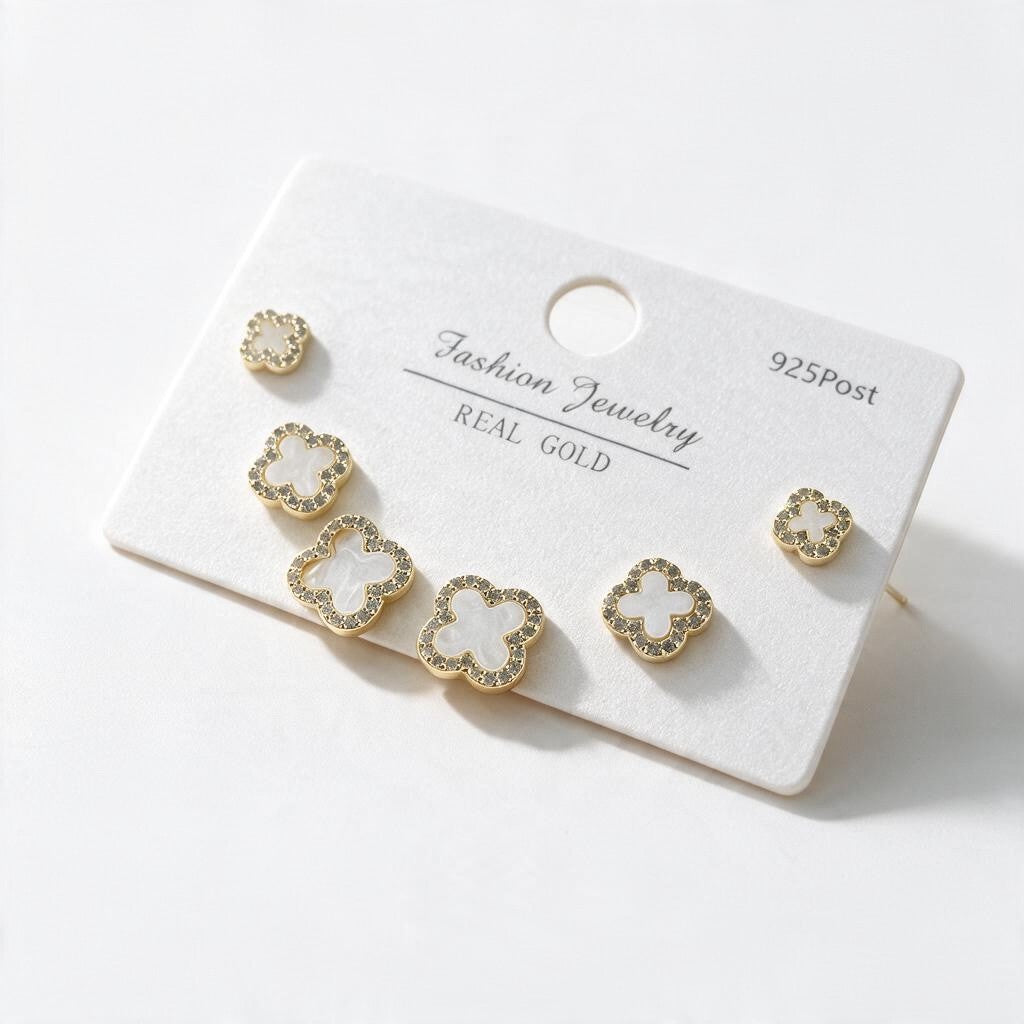 Gold clover stud set in three sizes with white centres and crystal borders on a card