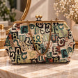 Teal green and cream tapestry handbag with Armenian letters, brass kiss clasp and chain strap on a vanity