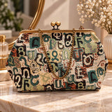 Teal green and cream tapestry handbag with Armenian letters, brass kiss clasp and chain strap on a vanity