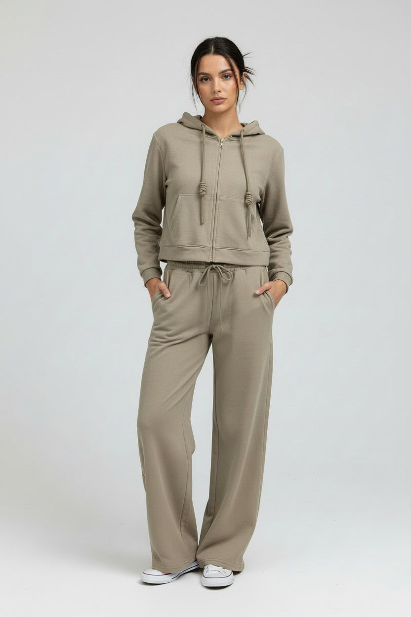 Olive green hoodie and sweatpants worn by a person on a neutral background