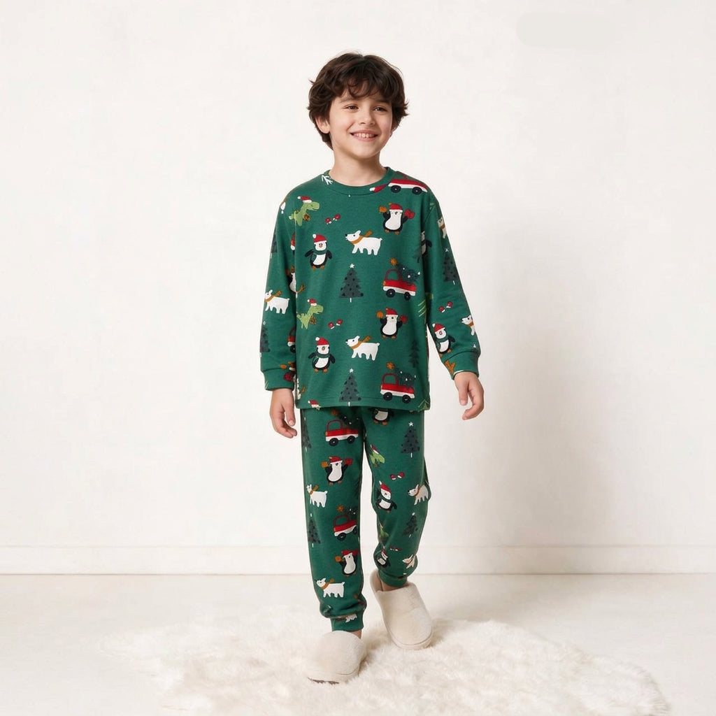 Boy wearing the green Christmas penguin print pajama top and cuffed pants