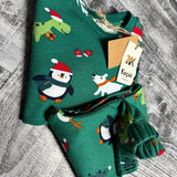 Close up of penguins in Santa hats and polar bears on green pajama fabric