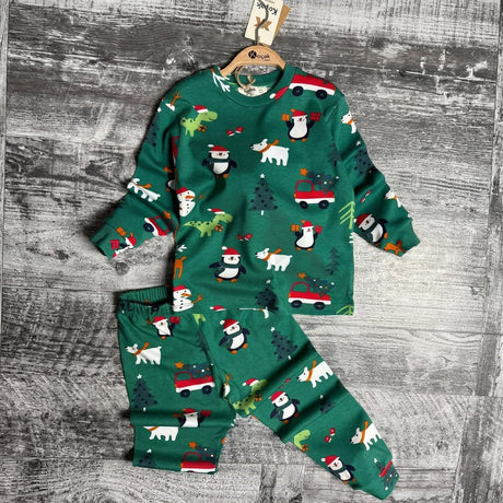 Green penguin and polar bear print pajama top and pants laid flat