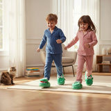 Two children in pyjamas walking in green crocodile slippers
