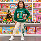 Girl in a green Festive Friends Christmas sweatshirt and cream printed leggings in a toy store