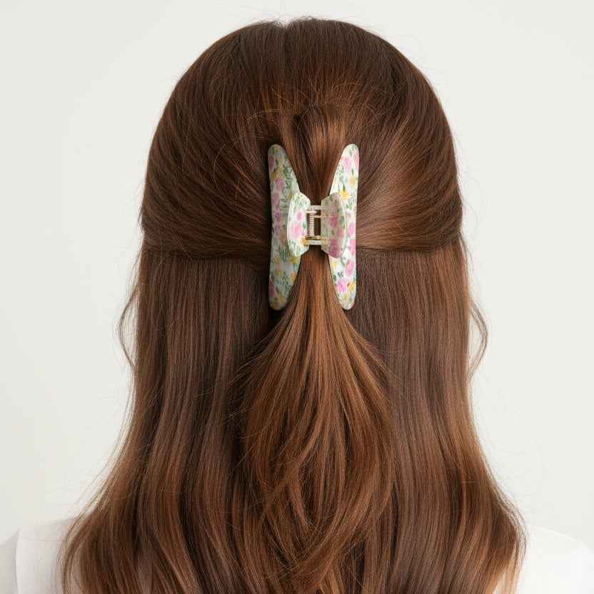 Pale green and pink floral claw clip seen from behind in auburn hair