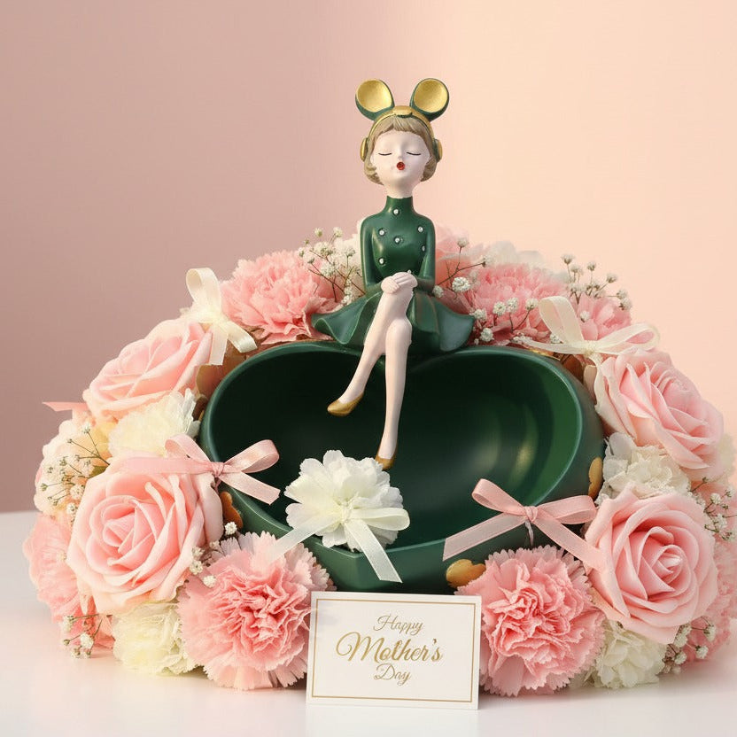 Green heart bowl ringed with pink and cream roses beside a small greeting card