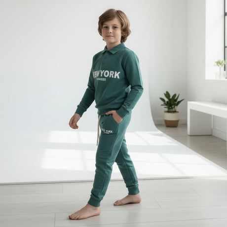 Full length side view of a boy in a green polo collar sweatshirt and jogger lounge set